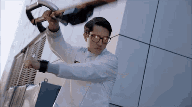 a man wearing glasses is holding a sword