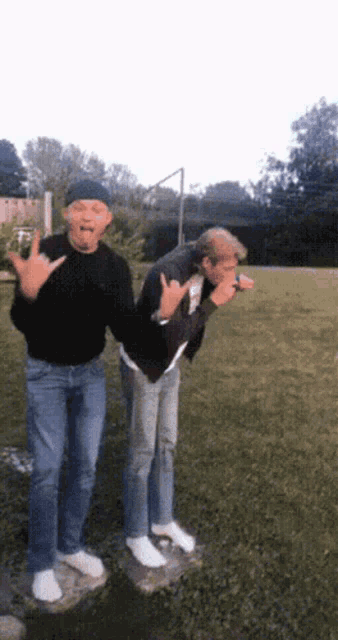 a man in a black sweater is standing next to another man in jeans