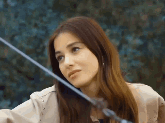a close up of a woman 's face with a rope in the background