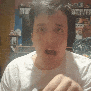 a man with a surprised look on his face is standing in front of a room that has a sign that says roomtac