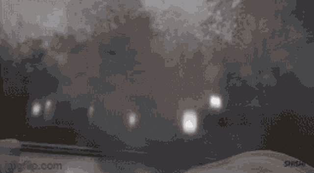 a gif of a car driving down a snowy road at night