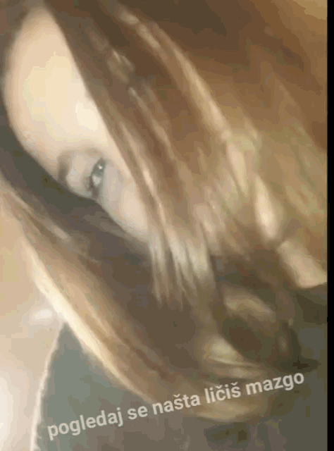 a close up of a woman 's face with the words " pogledaj se nasta licis mazgo " below her