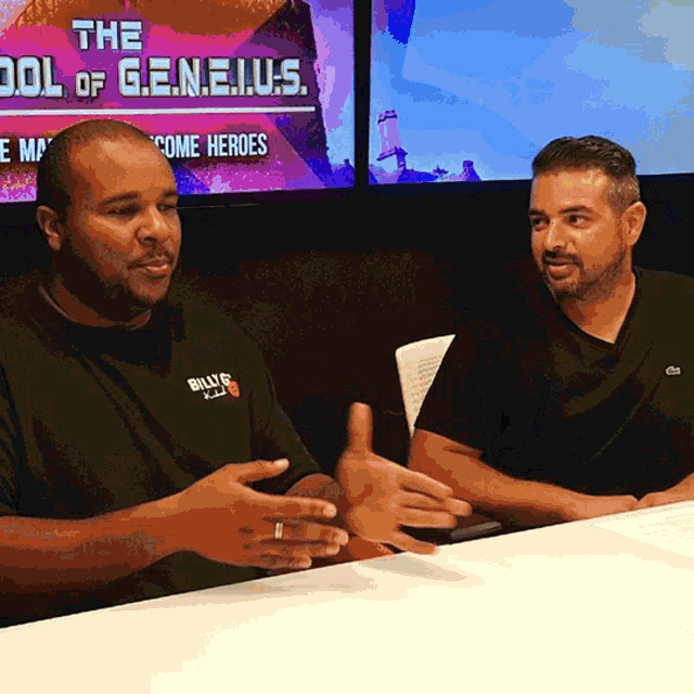 two men are sitting at a table in front of a screen that says the cool of geneius