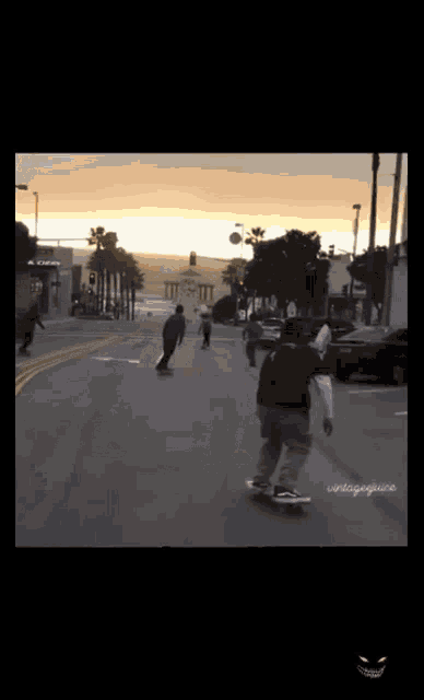 a man is riding a skateboard down a street at sunset ..