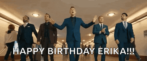 a group of men in suits and ties are walking down a hallway and singing happy birthday erika