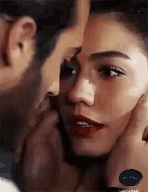 a man is touching a woman 's face while they are kissing .