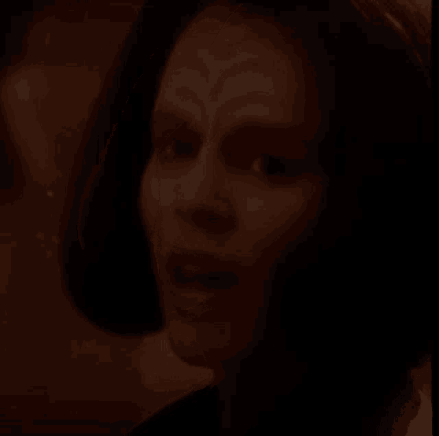 a close up of a woman 's face in the dark with a blurred background .
