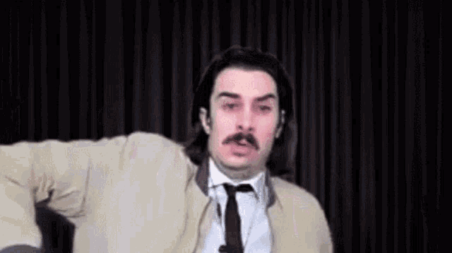 a man in a suit and tie is making a funny face .