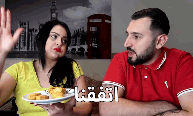 a man in a red shirt talks to a woman in a yellow shirt