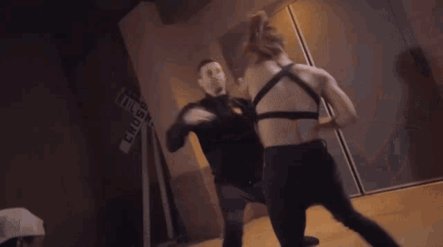a group of people are fighting in a room .