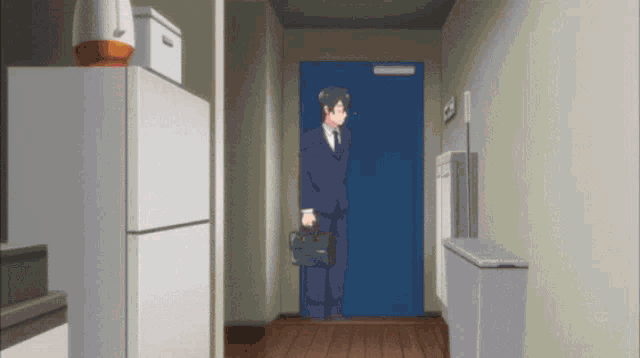 a man in a suit and tie is standing in front of a door