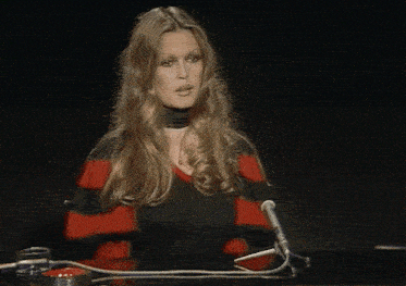 a woman in a red and black striped sweater sits at a table