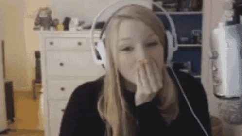 a woman wearing headphones is covering her mouth