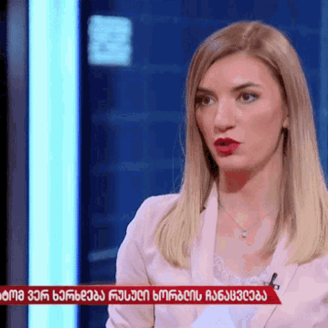 a woman in a pink jacket talks on a television show
