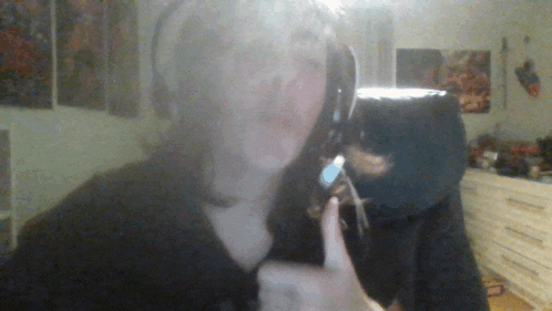 a woman wearing headphones is holding her finger to her mouth