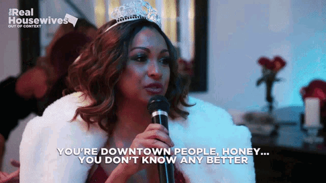 a woman holding a microphone with the words " you 're downtown people honey you don 't know any better " written below her