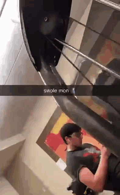 a man is standing in front of a staircase with a caption that says " swole mon "