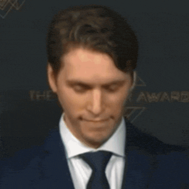 a man wearing headphones is smiling in front of a sign that says " eliminated ishows "