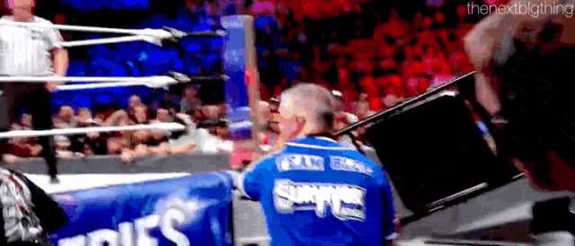 a wrestler in a blue shirt with the word supers on it