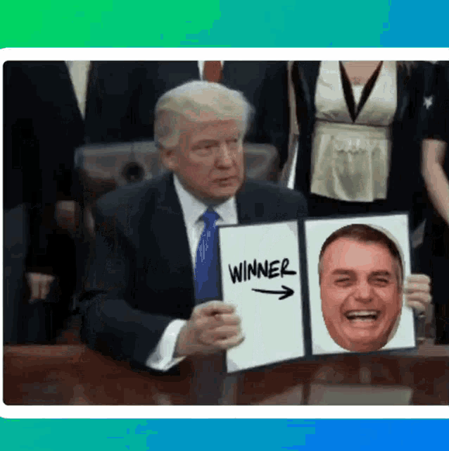 a man in a suit and tie is holding a piece of paper that says winner