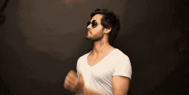 a man wearing sunglasses and a white t-shirt has a tattoo on his neck