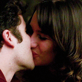 a man and a woman are kissing and the woman is smiling .