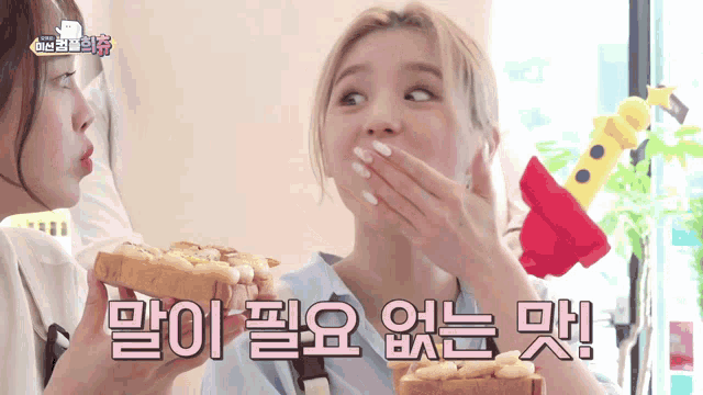 a woman covering her mouth with her hand while holding a piece of toast