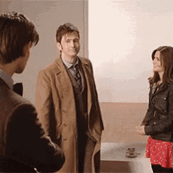a man in a tan coat is talking to a woman in a red skirt