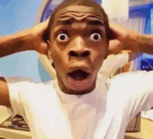 a man is making a funny face with his hands on his head and his mouth open .
