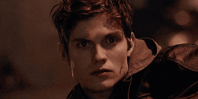 a close up of a young man with blood on his face