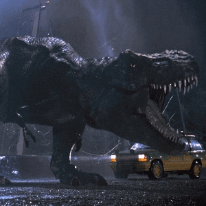 a jurassic park vehicle is parked in front of a dinosaur