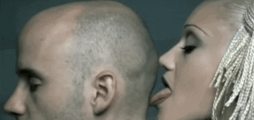 a man and a woman are kissing with the woman sticking out her tongue