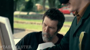 a man with a beard is reading a piece of paper