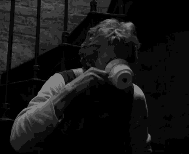 a black and white photo of a man drinking from a mug that says usl