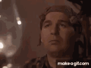 a man with a bandana on his head is smiling and looking up