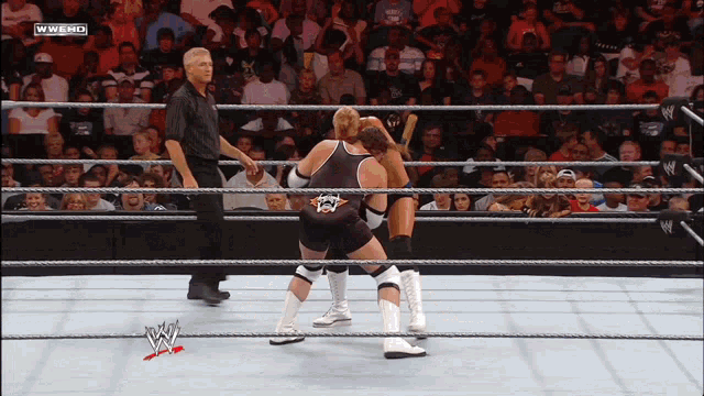 two wrestlers in a wrestling ring with a referee and the words wwe hd on the bottom