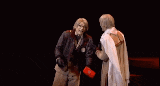 two men are shaking hands in a dark room