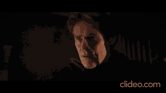 a close up of a man 's face with the website clideo.com in the background