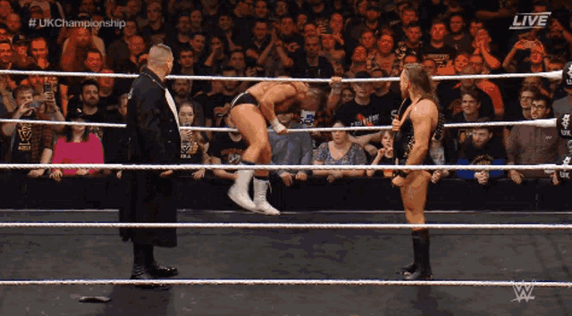 two wrestlers in a wrestling ring with the words live on the bottom right