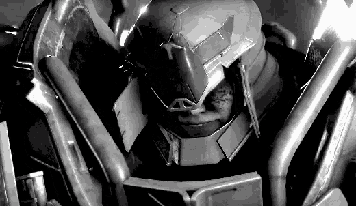 a black and white photo of a robot wearing a helmet and armor .