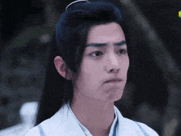 a man with long black hair is making a funny face .