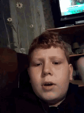 a young boy is looking at the camera in front of a tv screen that says netflix