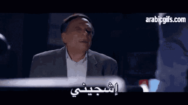 a man in a suit is making a funny face while talking to another man in arabic .
