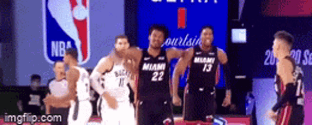 a group of basketball players standing on a court with miami on their jerseys