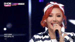 a woman with red hair is singing into a microphone on show