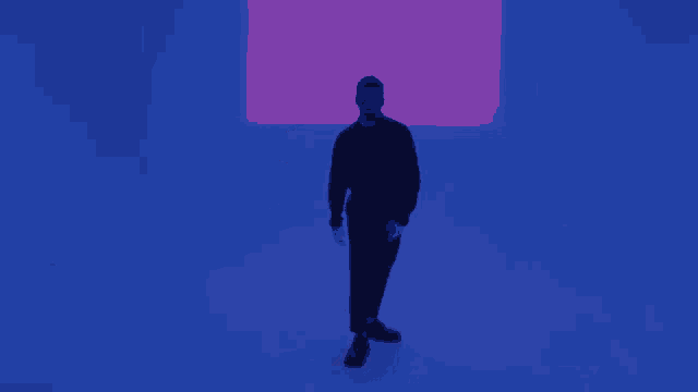 a man stands in front of a pink and blue light