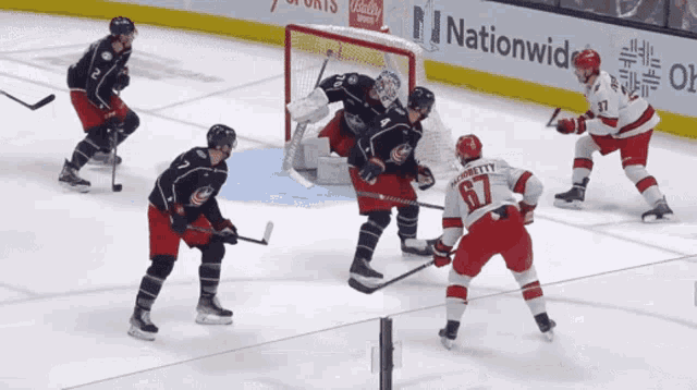 a hockey game is being played in front of a sign that says nationwide on it