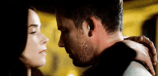 a man and a woman are kissing in a room .
