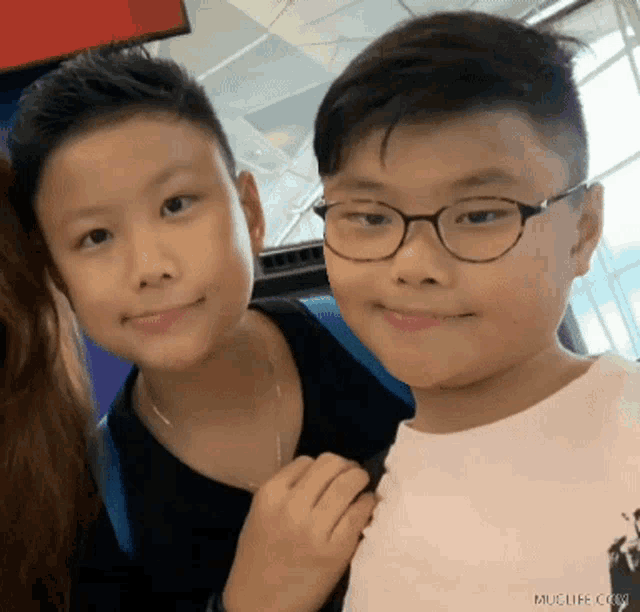 two boys wearing glasses are posing for a picture
