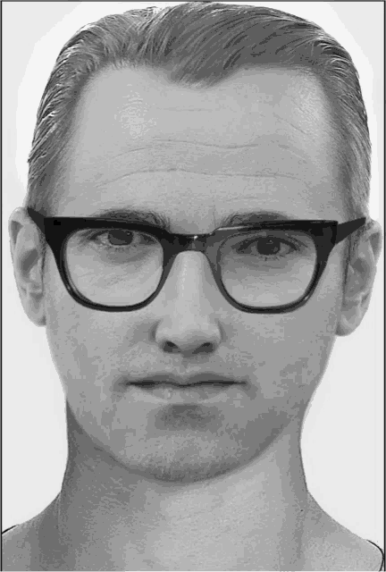 a man wearing glasses looks at the camera with a serious look on his face